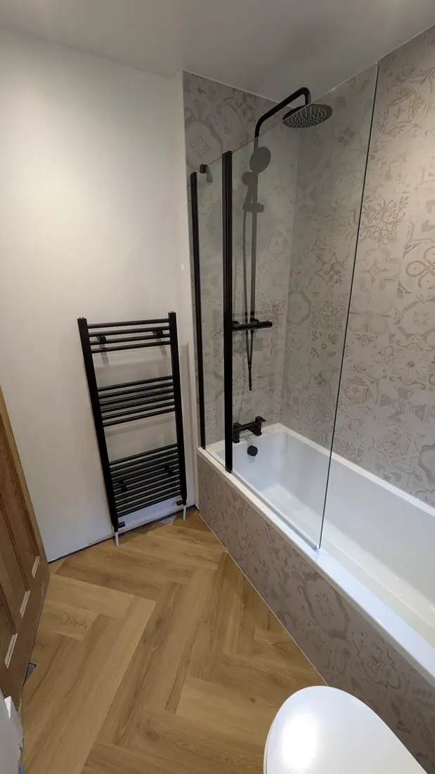 A shower bath with herringbone flooring by Pete Hughes Property Services