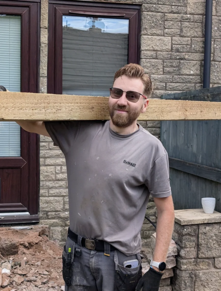 Pete Hughes carrying timber on site